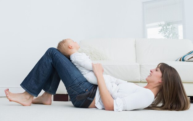 Mère allongée sur le sol avec un bébé