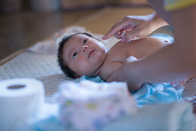 Mère appliquant de la poudre de bébé avant de mettre des couches