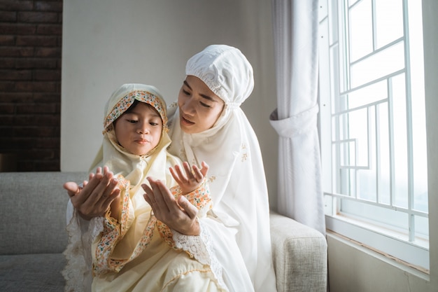 Mère apprend à sa fille à prier