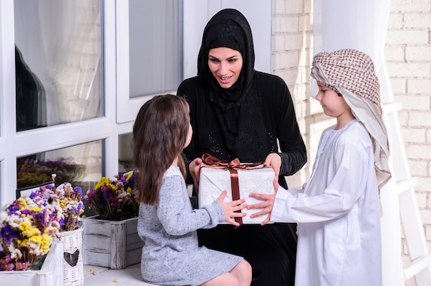 Mère arabe offrant un cadeau à ses enfants.