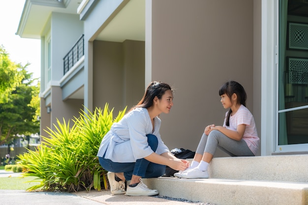 Mère asiatique aide sa fille à nouer des lacets