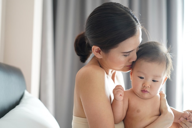 Mère asiatique embrasse sa tête d&#39;enfant avec sentiment d&#39;amour.