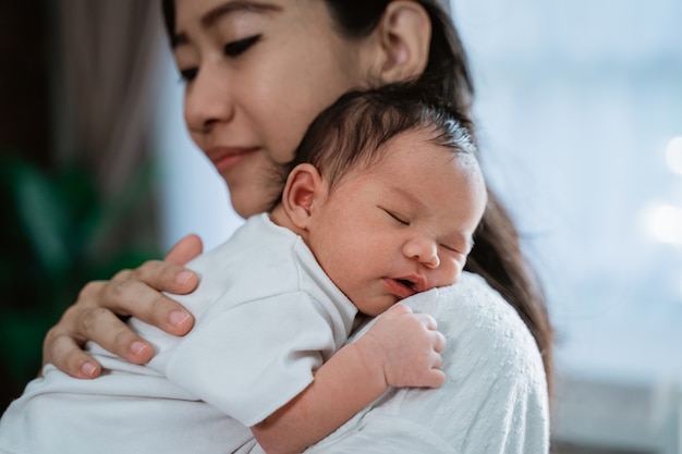 Mère asiatique embrasse transportant une petite fille nouveau-née