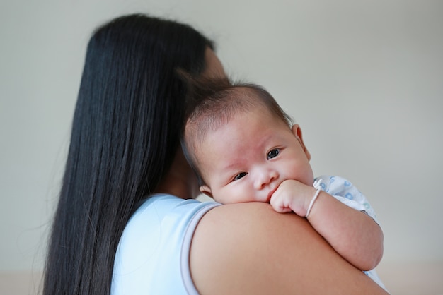 Mère asiatique portant bébé dans la chambre.