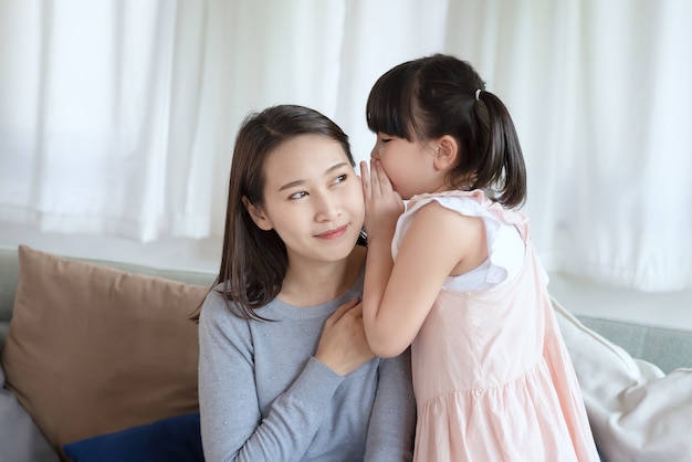 Une mère asiatique se sent heureuse en jouant sa jolie fille avec amour et attention à la maison