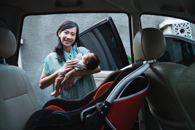 Mère Asiatique Sourire En Portant Sa Petite Fille