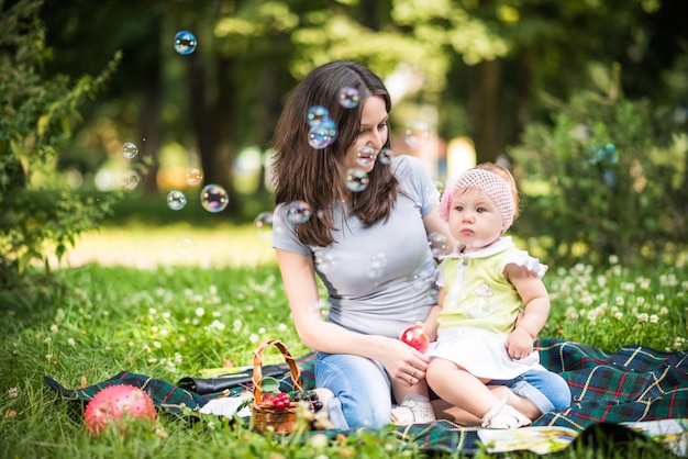 Mère assise sur l'herbe avec sa petite fille