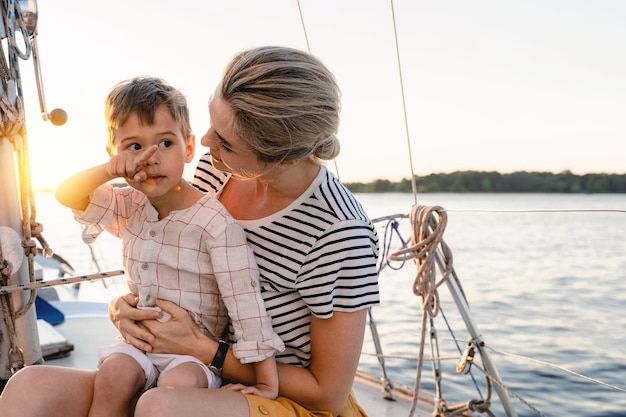 Mère attrayante avec son adorable fils en bas âge naviguant en mer sur un voilier