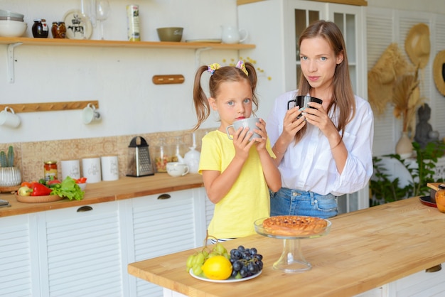 Mère et bébé cuisinent ensemble des aliments sains dans la cuisine et s'amusent