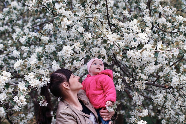 Mère avec bébé dans un arbre de forêt de jour ensoleillé de jardin d'été