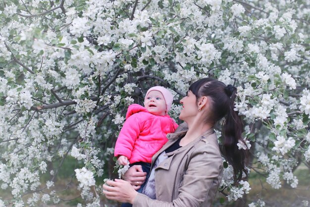 Mère avec bébé dans le jardin de pommiers