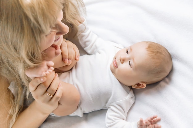 Mère avec bébé sur fond clair. Mise au point sélective. Gens.