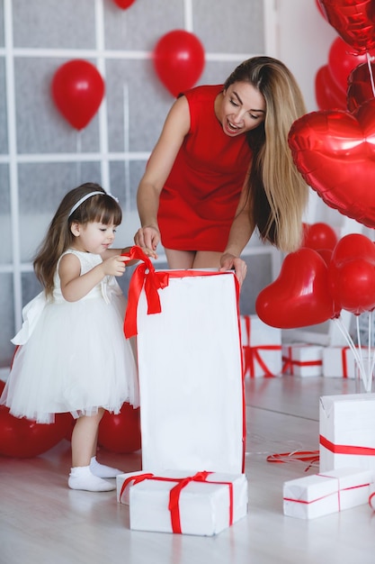 mère avec bébé mignon à l'intérieur avec cadeau