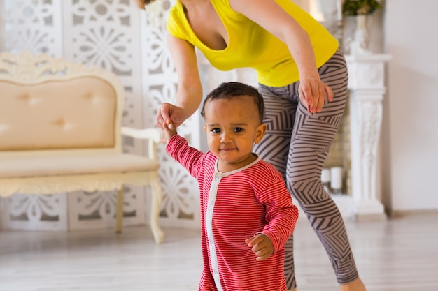 Mère et bébé de race mixte jouant à la maison.