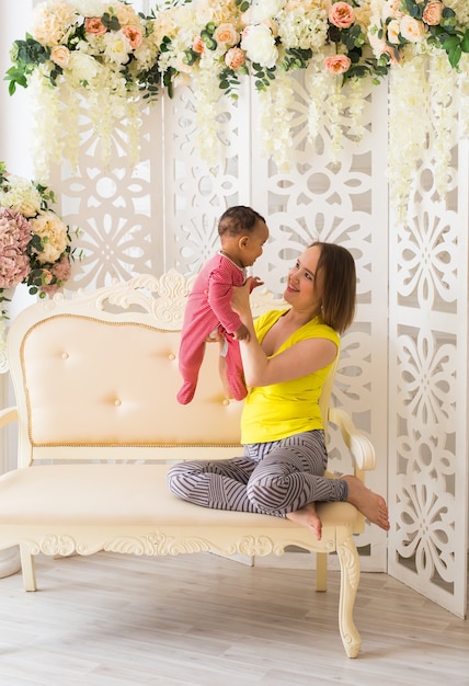 Mère et bébé de race mixte jouant à la maison.