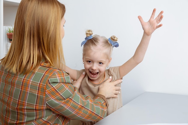 Mère chatouillant sa fille et jouant avec elle