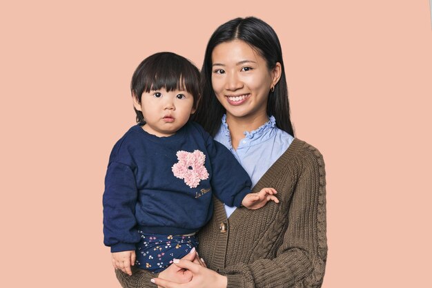 Une mère chinoise heureuse serrant son enfant.