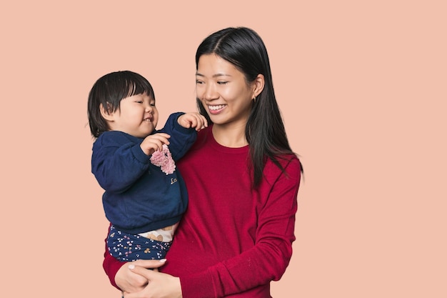 Une mère chinoise heureuse serrant son enfant.