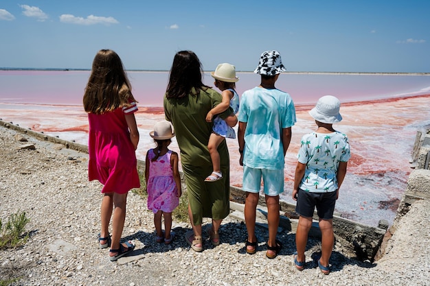 Mère de cinq enfants contre le lac salé rouge à Saline Margherita di Savoia d'Italie