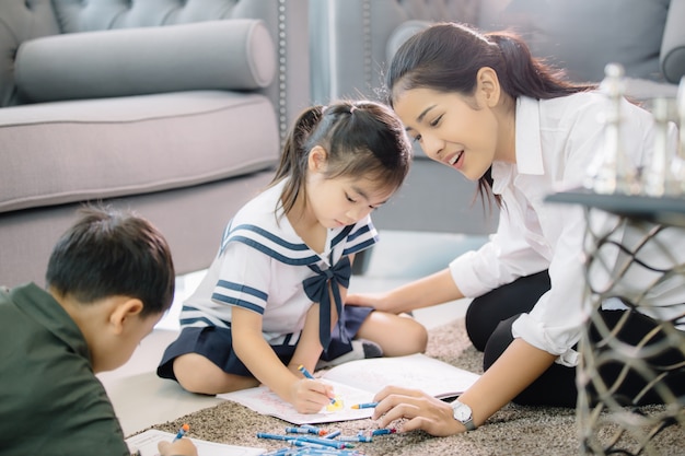 Mère à colorier avec ses enfants à la maison