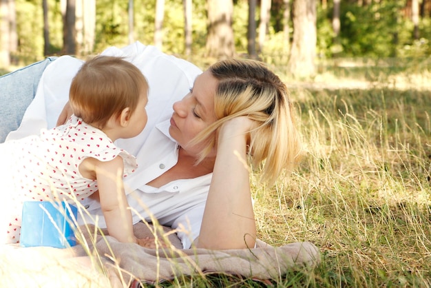 la mère communique avec sa petite fille dans le parc par une journée ensoleillée