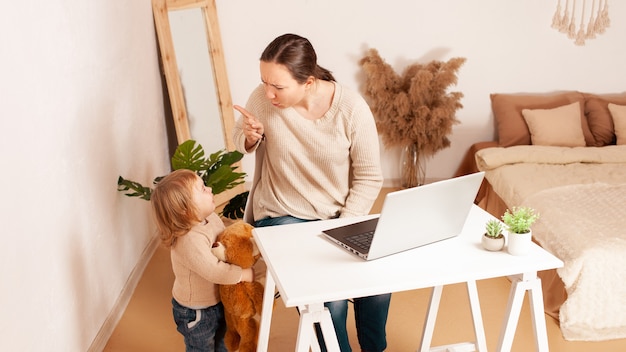 Une Mère En Congé De Maternité Est Assise Devant Un Ordinateur Portable Et Travaille Un Enfant Qui Crie Hystériquement Pleure Distrait