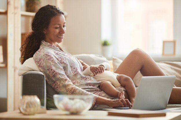 Mère contemporaine à l'aide d'un ordinateur portable