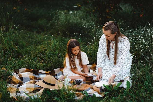 Une mère coupe un morceau de gâteau pour sa fille