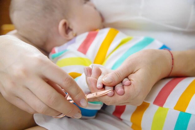 La mère coupe les ongles du petit bébé Mise au point sélective