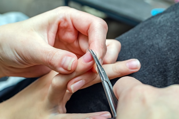 La mère coupe les ongles de l'enfant. Coupez les ongles de votre enfant.