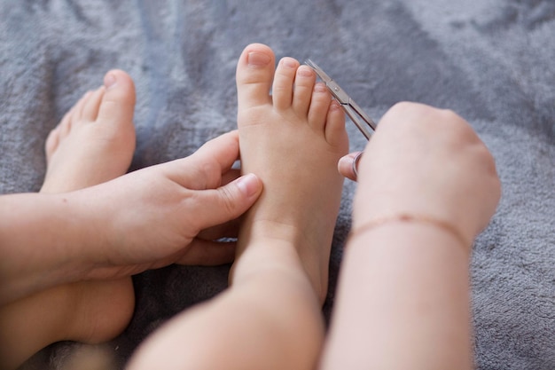 La mère coupe les ongles de l'enfant