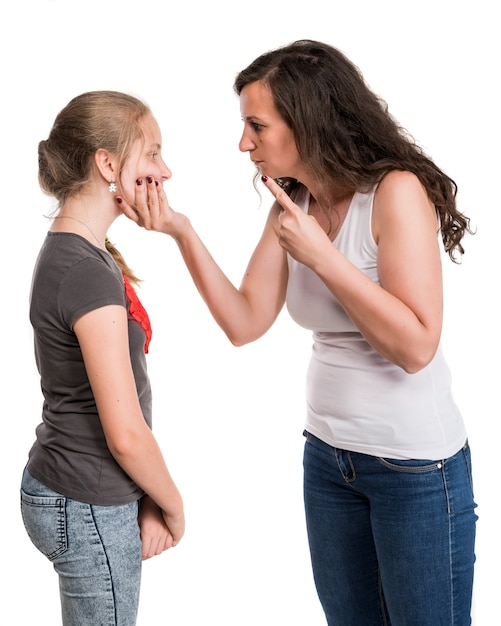 Mère criant à sa fille adolescente sur un mur blanc