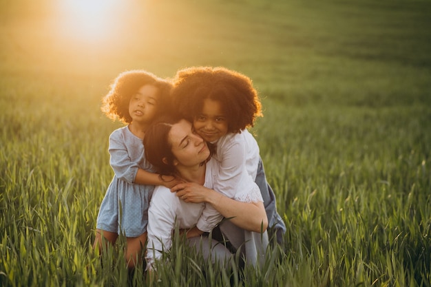 Mère avec deux enfants afro-américains sur le terrain au coucher du soleil