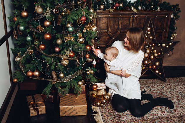 Mère avec deux enfants à arbre de noël