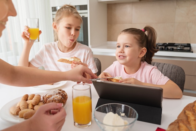 Mère et deux filles prenant leur petit déjeuner ensemble, concept de famille monoparentale heureuse