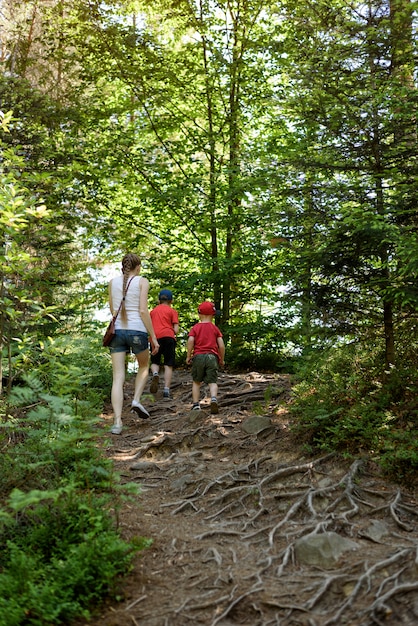 Mère et deux petits fils se promènent en forêt. Maternité et amitié