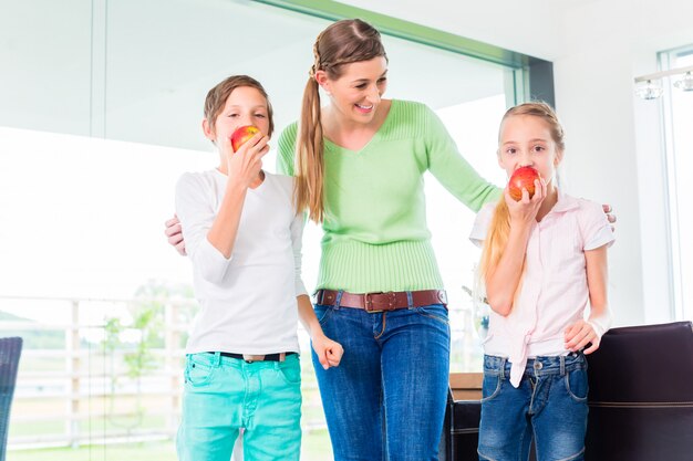 Mère donnant aux enfants des pommes pour une vie saine