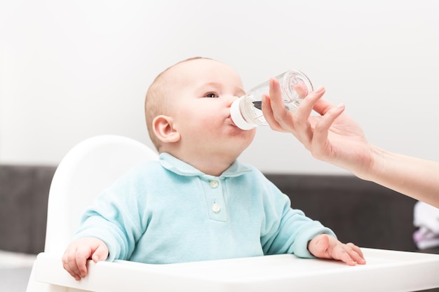 Mère donnant à bébé de boire de l'eau de la bouteille