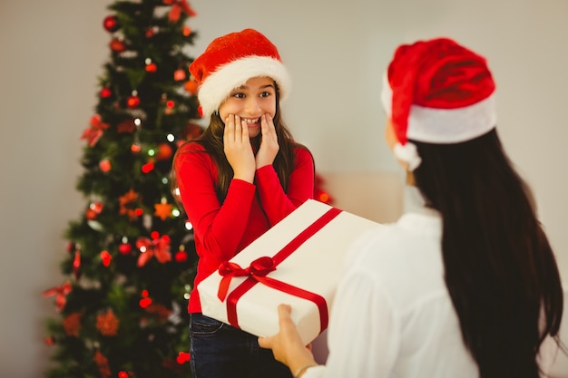 Mère donnant à sa fille un cadeau de Noël