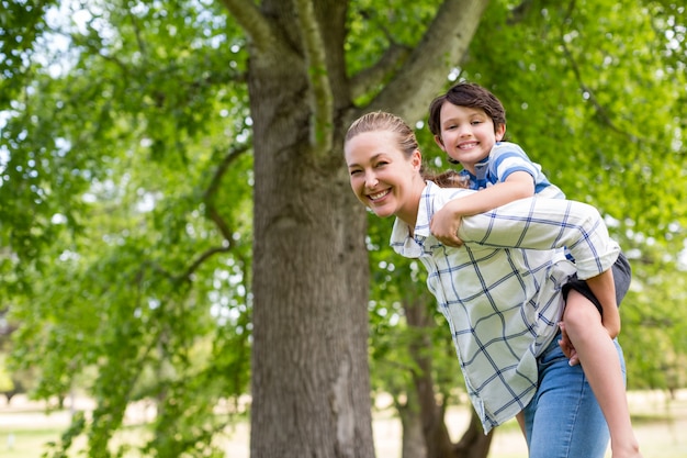 Mère donnant un tour de ferroutage à son fils dans le parc