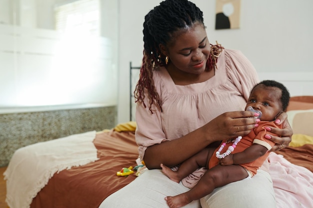 Photo une mère donne une sucette à son bébé.