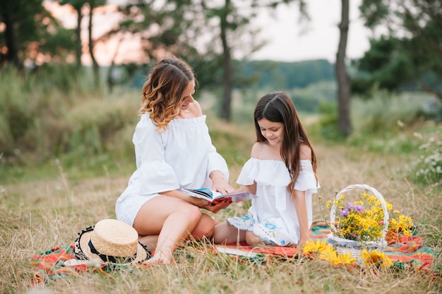 Mère élégante et belle fille s'amusant sur la nature