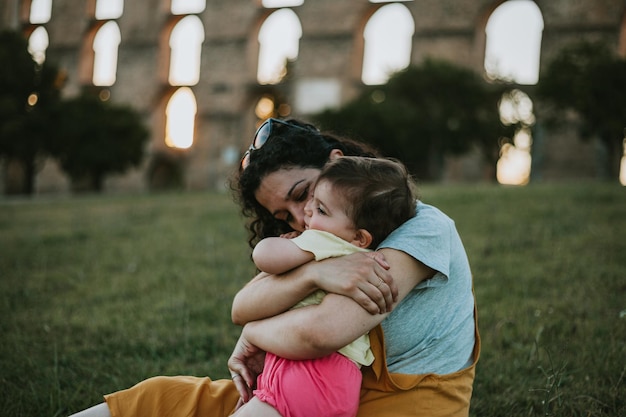 Mère embrassant sa fille sur le champ au coucher du soleil