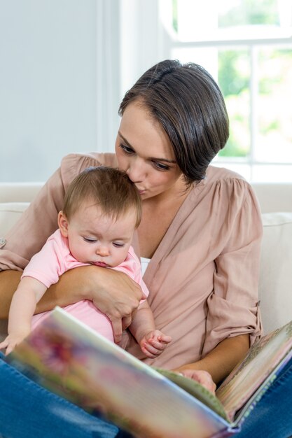 Mère embrassant son fils tout en regardant un livre d'images