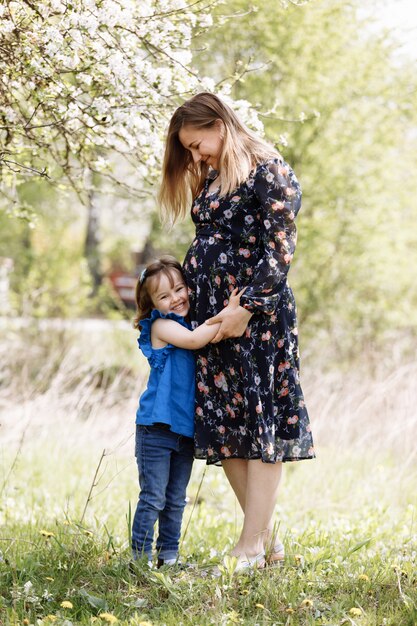 Mère enceinte avec sa fille dans la nature