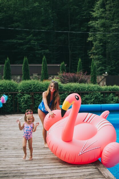 mère enceinte et sa fille flottait sur un flamant rose gonflable