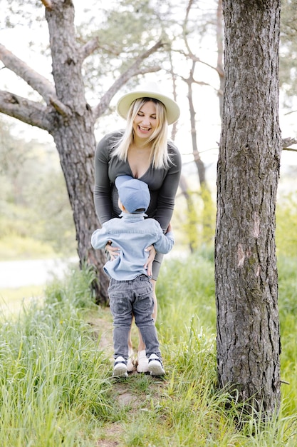 Mère enceinte et son petit fils marchant dans la forêt et passant du temps ensemble