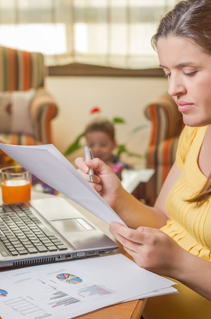 Mère enceinte travaillant au bureau à domicile avec son fils