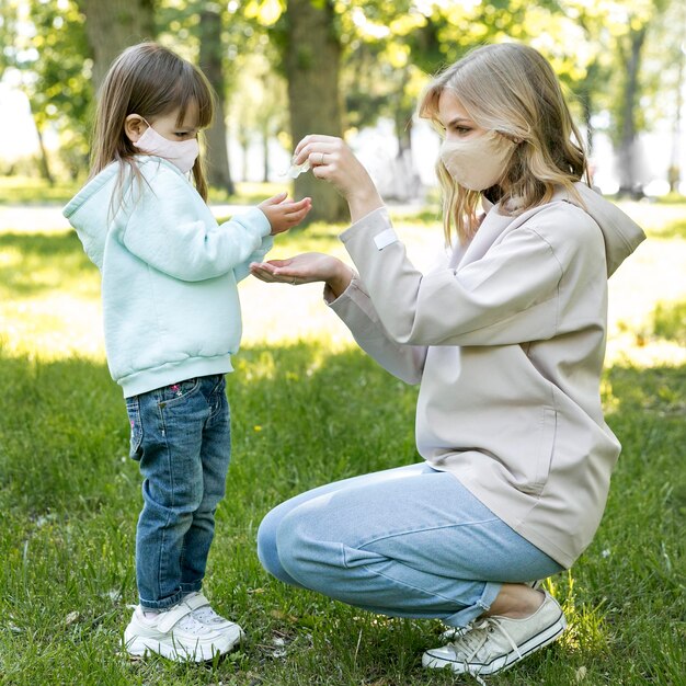 Mère et enfant à l'aide d'un désinfectant pour les mains