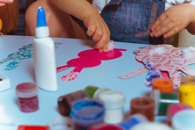 Mère avec enfant faisant un lapin en papier